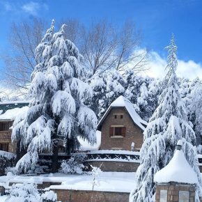 Haus im verschneiten Dorf mit schneebedeckten Tannenbäumen im Hohen Atlasgebirge in Marokko