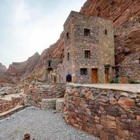 Traditionelles Steinhaus in einer felsigen Gebirgslandschaft im marokkanischen Atlasgebirge
