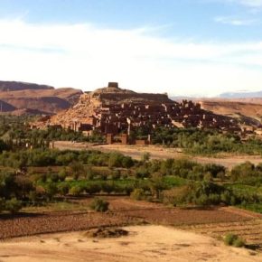Dramatischer Sonnenuntergang über der Wüste mit dunklen Wolken und orange leuchtendem Himmel
